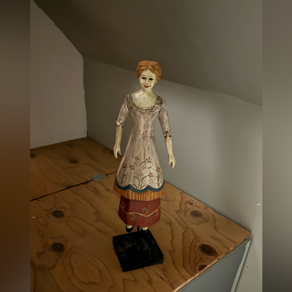 Hand painted, carved wood, jointed, lady figurine on a stand.